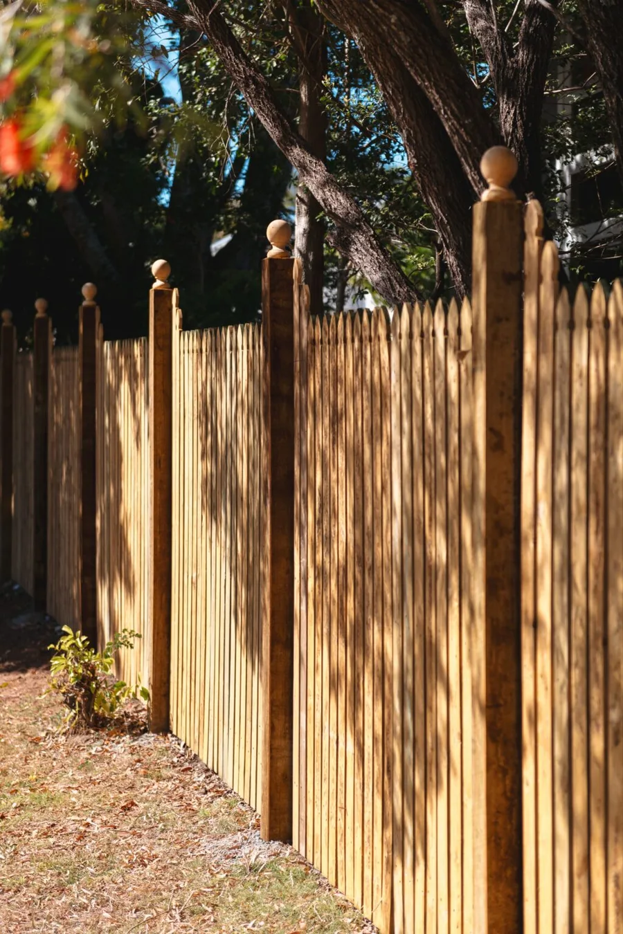 Heritage hardwood paling fence with classic ball-cap finials — hand-finished.