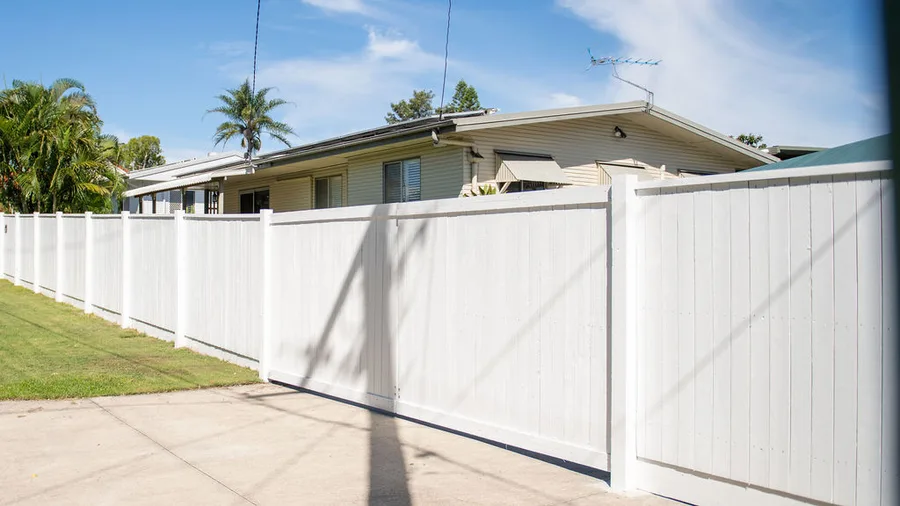 Painted timber boundary fence along driveway — clean lines, full privacy.