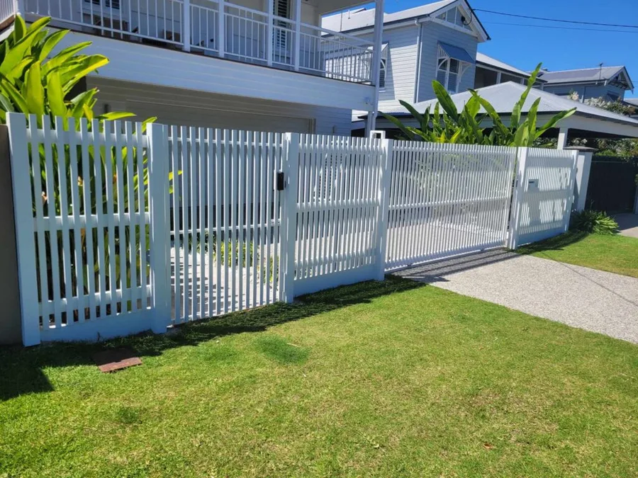 White slatted front fence with double driveway gate and pedestrian entry — modern coastal home.